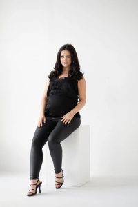 Model wearing black leather-look maternity leggings from the Mama collection.