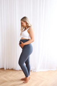 Woman wearing Seamless Luxe Maternity Leggings in slate, side view.