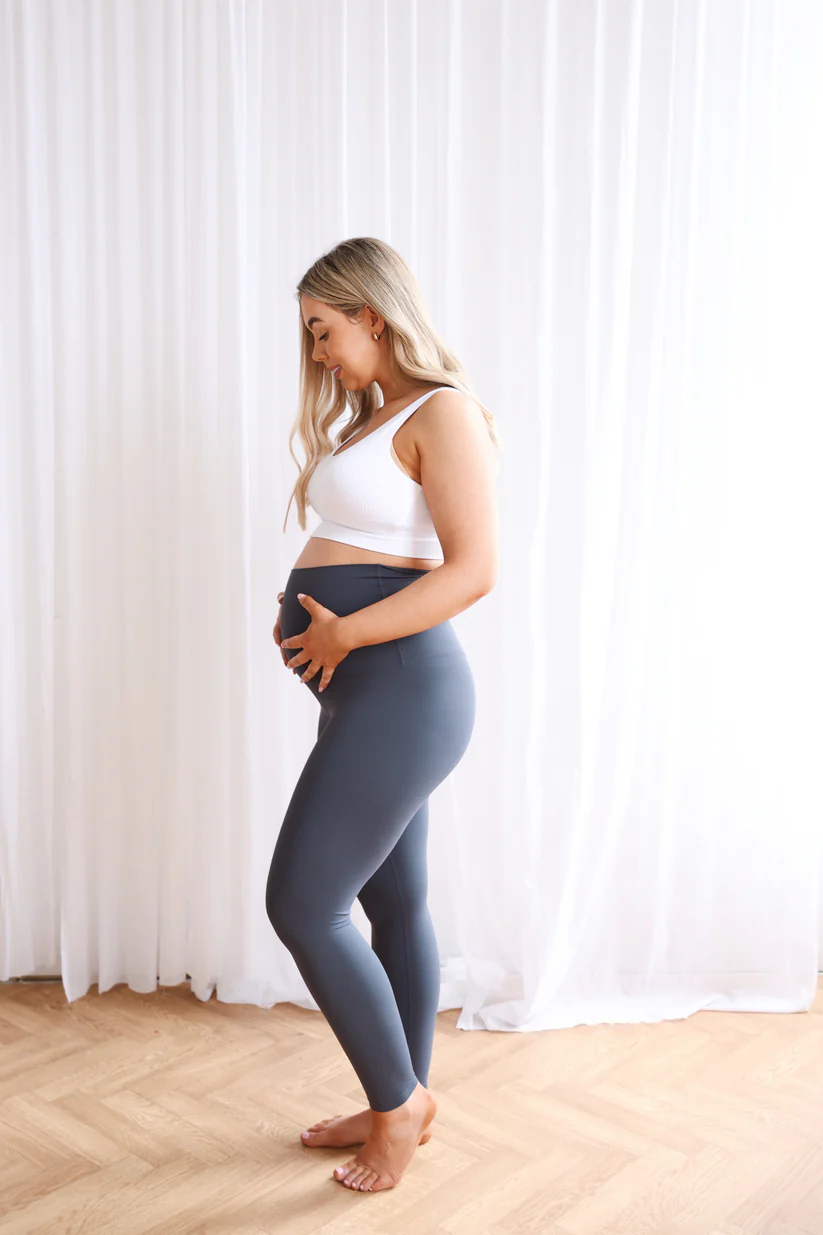 SeamlessLuxeLeggingsSlate_1 Woman wearing Seamless Luxe Maternity Leggings in slate, side view.