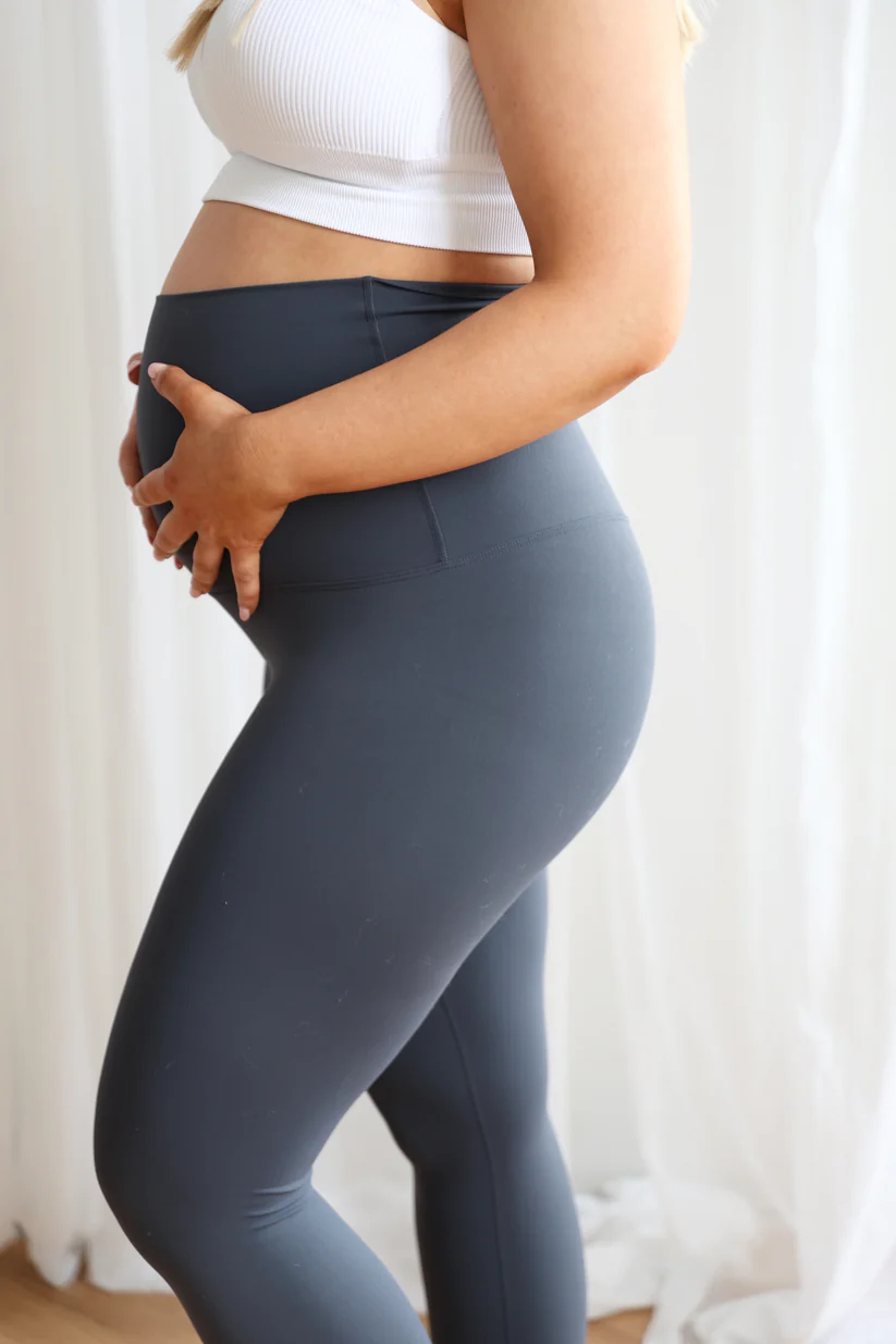 SeamlessLuxeLeggingsSlate_2 Woman wearing Seamless Luxe Maternity Leggings in slate, side view.