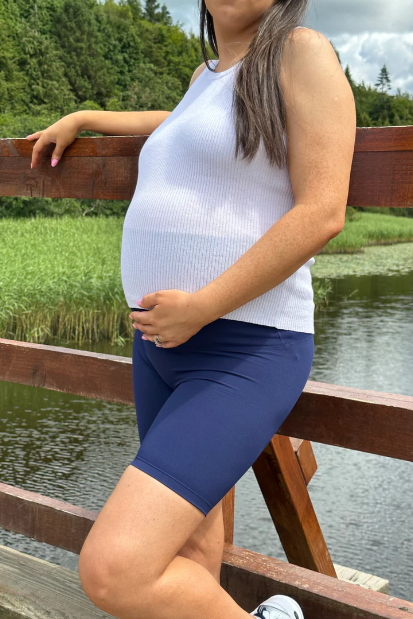 SeamlessSculptShorts_Navy_2 Model wearing navy seamless sculpt maternity shorts with high-waist support