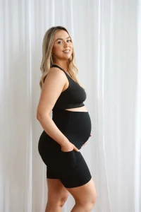 Model wearing black seamless maternity shorts with high waistband.